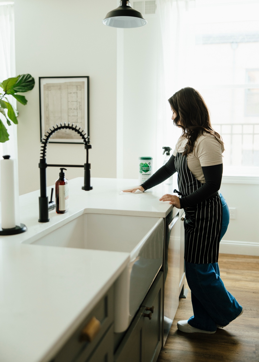 The owner of EVE Home Services wiping down a kitchen counter.